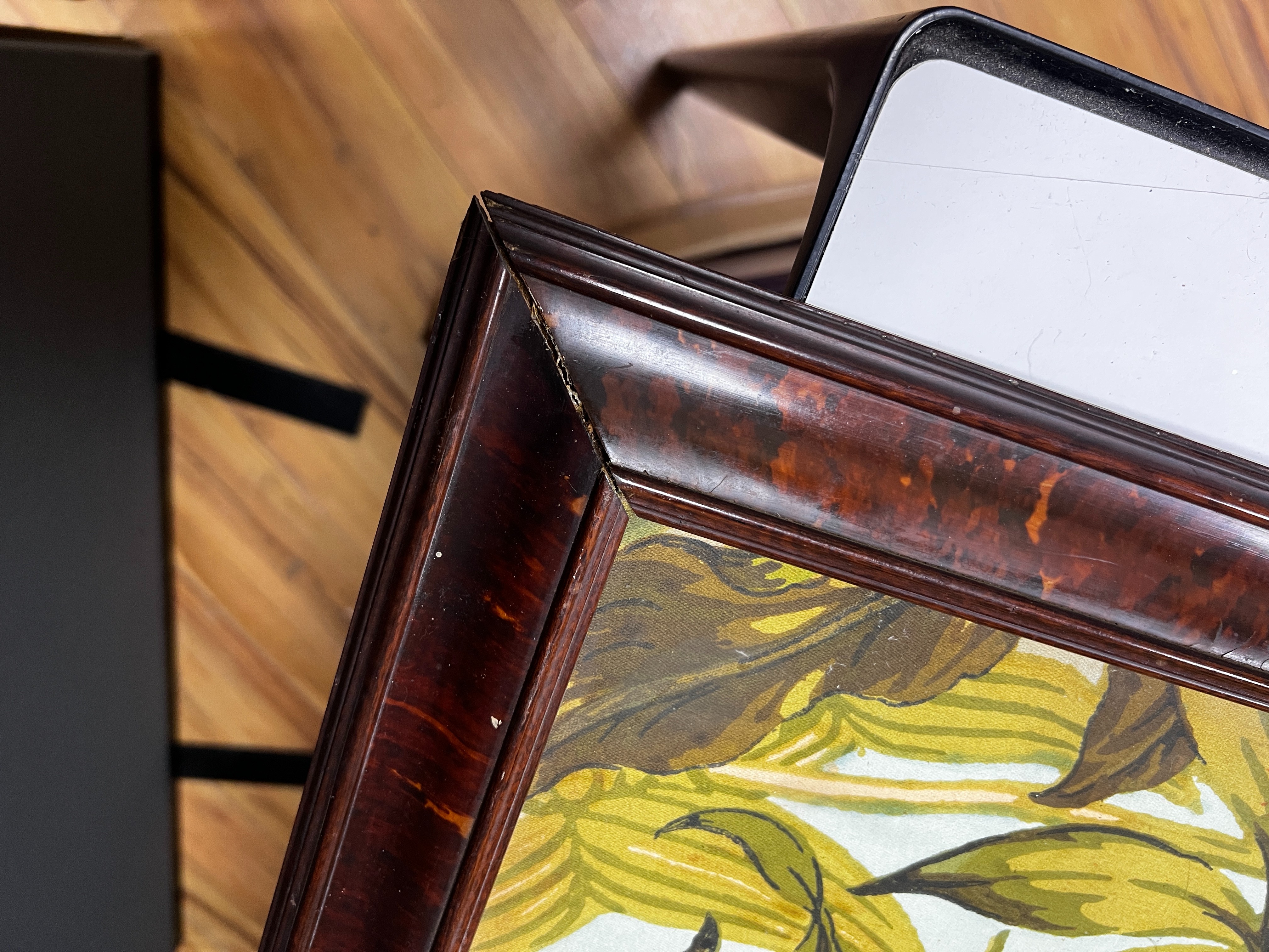 A large rare tortoiseshell picture frame and exotic panel of printed fabric, 70 cms wide x 52 cms high including frame